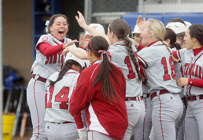 Briana Knight (#14) is greeted at home plate after her grand slam in Sunday's win over UCSB. (John Medina Photo)